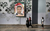 People walk past a banner showing Iran's Revolutionary Guard Col. Hassan Sayyad Khodaei prior to his funeral ceremony, in Tehran, Iran, May 24, 2022. (Vahid Salemi/AP)
