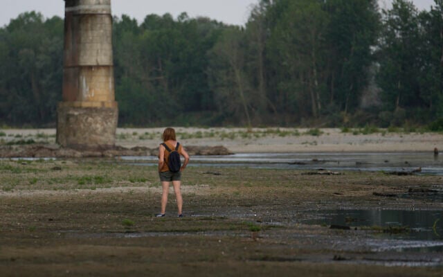 A woman stands on the dry Po rice paddy riverbed next to the Becca Bridge in Linarolo, near Pavia, Italy, June 27, 2022 during Italy's worst drought in 70 years. (AP/Luca Bruno) A woman stands on the dry Po rice paddy riverbed next to the Becca Bridge in Linarolo, near Pavia, Italy, June 27, 2022 during Italy's worst drought in 70 years. (AP/Luca Bruno)