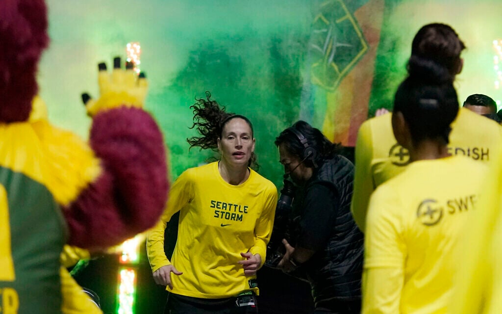 Seattle Storm guard Sue Bird, center, runs out of the tunnel before a WNBA basketball playoff game against the Washington Mystics, August 21, 2022 in Seattle. (AP Photo/Ted S. Warren)