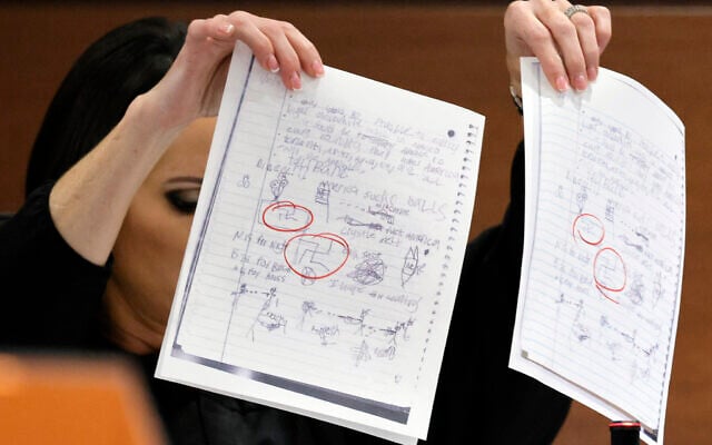 Judge Elizabeth Scherer holds up documents as she considers arguments from the defense that the jury should be prevented from seeing the swastikas on the pages (circled in red) during the trial of Marjory Stoneman Douglas High School shooter Nikolas Cruz at the Broward County Courthouse in Fort Lauderdale, Fla., on Thursday, Sept. 1, 2022. (Amy Beth Bennett/South Florida Sun-Sentinel via AP, Pool) Judge Elizabeth Scherer holds up documents as she considers arguments from the defense that the jury should be prevented from seeing the swastikas on the pages (circled in red) during the trial of Marjory Stoneman Douglas High School shooter Nikolas Cruz at the Broward County Courthouse in Fort Lauderdale, Fla., on Thursday, Sept. 1, 2022. (Amy Beth Bennett/South Florida Sun-Sentinel via AP, Pool)