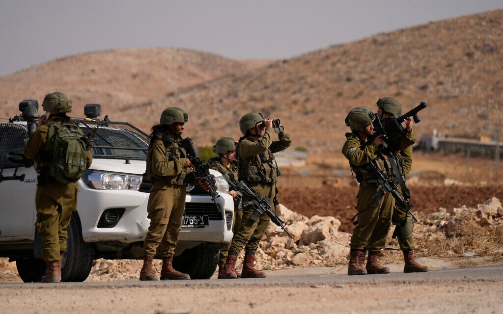 Israeli soldiers stand guard at a roadblock following a shooting attack in the West Bank in the Jordan Valley, Sunday, Sept. 4, 2022. (AP/Majdi Mohammed)