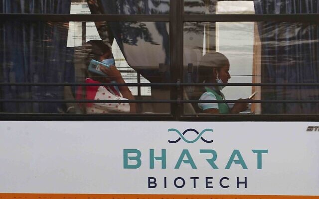An employee of Bharat Biotech speaks on a mobile phone inside a bus on the outskirts of Hyderabad, India, January 9, 2021. (AP Photo/Mahesh Kumar A., File)