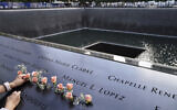 Mourners place flowers in the name cut-out of Kyung Hee (Casey) Cho at the National September 11 Memorial and Museum in New York, Sept. 11, 2020 (AP Photo/John Minchillo, File)