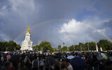 People gather outside Buckingham Palace in London as a double rainbow appears in the sky, Thursday, Sept. 8, 2022. (AP Photo/Frank Augstein)