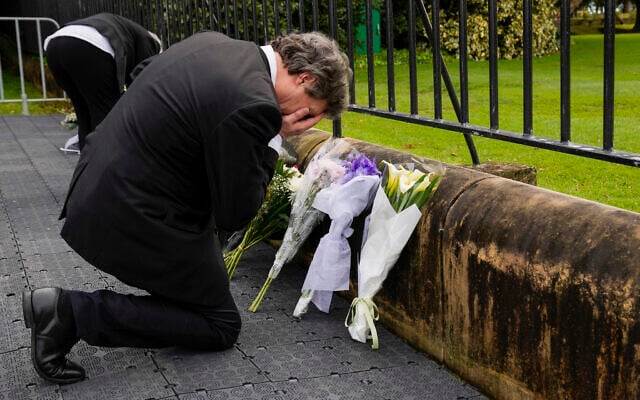 A man reacts after laying flowers outside Government House following the passing of Queen Elizabeth II in Sydney, Australia, September 9, 2022. (AP Photo/Mark Baker)