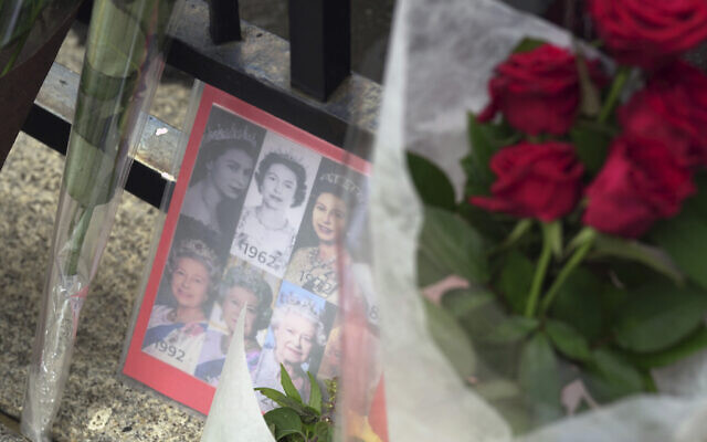 A condolence card with photos of Queen Elizabeth II, September 9, 2022, is placed outside the British Embassy in Tokyo. (AP Photo/Eugene Hoshiko)