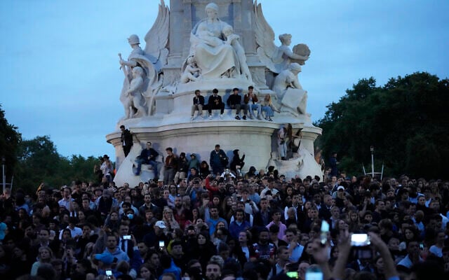 People gather outside Buckingham Palace in London, Thursday, Sept. 8, 2022, after the death of Britain's Queen Elizabeth II was announced. Queen Elizabeth II, Britain's longest-reigning monarch and a rock of stability across much of a turbulent century, died Thursday after 70 years on the throne. She was 96. (AP Photo/Frank Augstein)