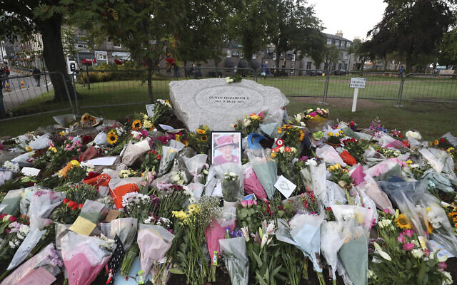 Floral tributes are placed in Ballater, Scotland ahead of the hearse carrying the coffin of Queen Elizabeth II before it passes through to make its journey to Edinburgh from Balmoral in Scotland, Sept. 11, 2022 (AP Photo/Scott Heppell)