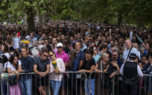 People wait in line to lay flowers for Queen Elizabeth II in front of Buckingham Palace, in London, September 11, 2022. (Nariman El-Mofty/AP)