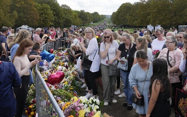People bring flowers to Windsor Castle in Windsor, England, September 11, 2022. (Martin Meissner/AP)