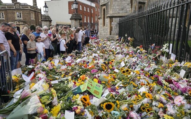 Crowds of people walk to Windsor Castle to bring flowers, in Windsor, England, September 11, 2022. (Martin Meissner/AP)