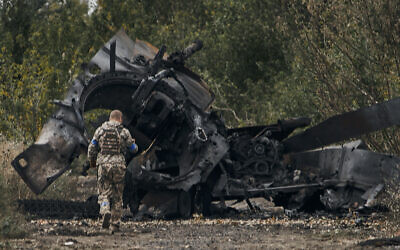 A Ukrainian soldier passes by a Russian tank damaged in a battle in a just freed territory on the road to Balakleya in the Kharkiv region, Ukraine, September 11, 2022. (AP Photo)