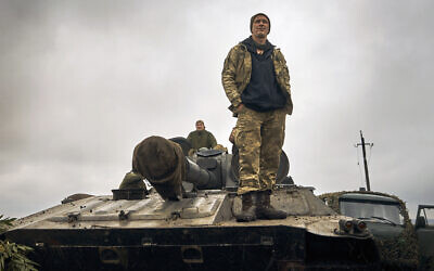 A Ukrainian soldier stands on a tank on the road in the freed territory of the Kharkiv region, Ukraine, September 12, 2022. (AP Photo/Kostiantyn Liberov)