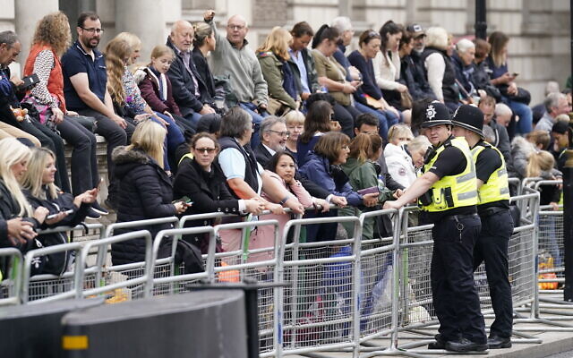 People wait ahead of the ceremonial procession of the coffin of Queen Elizabeth II from Buckingham Palace to Westminster Hall, in in Westminster, central London, September 14, 2022. (Danny Lawson/PA via AP) People wait ahead of the ceremonial procession of the coffin of Queen Elizabeth II from Buckingham Palace to Westminster Hall, in in Westminster, central London, September 14, 2022. (Danny Lawson/PA via AP)