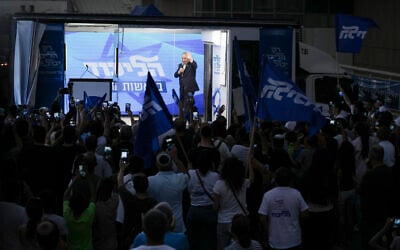 Likud leader Benjamin Netanyahu delivers an election campaign speech from inside a modified delivery truck with a side wall replaced with bulletproof glass, in Beersheba, southern Israel, September 13, 2022. (AP Photo/Ariel Schalit)