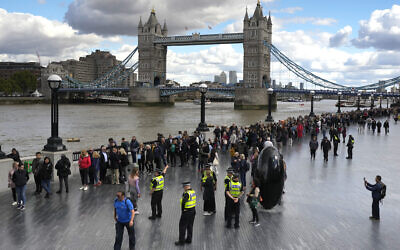 People walk in a queue in front of Tower Bridge to pay their respects to the late Queen Elizabeth II during the Lying-in State at Westminster Hall, in London, England, Friday, Sept. 16, 2022. The Queen will lie in state in Westminster Hall for four full days before her funeral on Monday Sept. 19. (AP Photo/Markus Schreiber)
