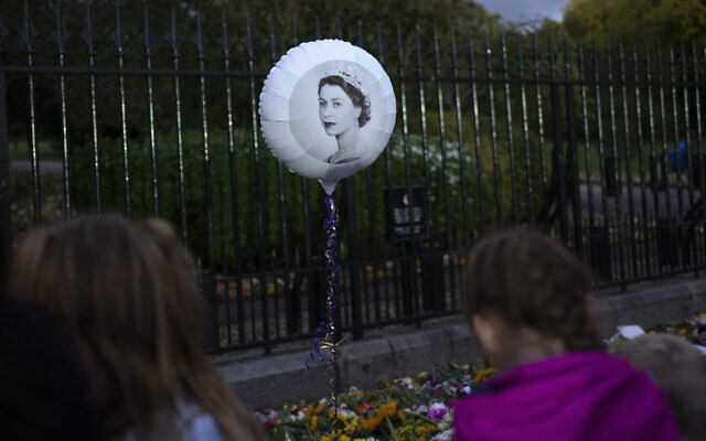 Members of the public are seen outside Windsor Castle by floral tributes for the late Queen Elizabeth II in Windsor, England, September 18, 2022. (AP Photo/Jon Super)