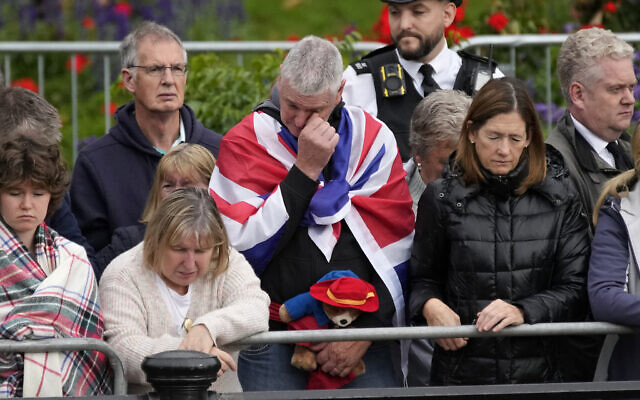 A person holding a Paddington Bear stuffed toy stands with members of the public outside Buckingham Palace waiting to watch Queen Elizabeth II funeral procession, in central London Monday, Sept. 19, 2022. The Queen, who died aged 96 on Sept. 8, will be buried at Windsor alongside her late husband, Prince Philip, who died last year. (AP Photo/Christophe Ena, Pool) A person holding a Paddington Bear stuffed toy stands with members of the public outside Buckingham Palace waiting to watch Queen Elizabeth II funeral procession, in central London Monday, Sept. 19, 2022. The Queen, who died aged 96 on Sept. 8, will be buried at Windsor alongside her late husband, Prince Philip, who died last year. (AP Photo/Christophe Ena, Pool)