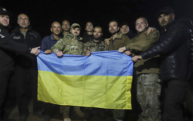 Ukrainian soldiers released in a prisoner exchange between Russia and Ukraine, hold the Ukrainian flag close to Chernihiv, Ukraine, Sept. 21, 2022. (Ukrainian Security service Press Office via AP) Ukrainian soldiers released in a prisoner exchange between Russia and Ukraine, hold the Ukrainian flag close to Chernihiv, Ukraine, Sept. 21, 2022. (Ukrainian Security service Press Office via AP)