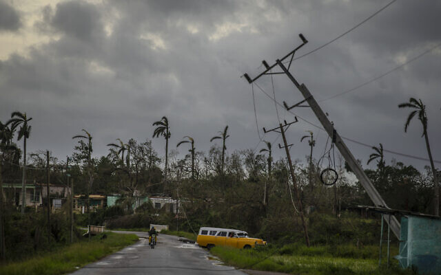 A classic American car drives past utility poles tilted by Hurricane Ian in Pinar del Rio, Cuba, Sept. 27, 2022. (AP Photo/Ramon Espinosa) A classic American car drives past utility poles tilted by Hurricane Ian in Pinar del Rio, Cuba, Sept. 27, 2022. (AP Photo/Ramon Espinosa)