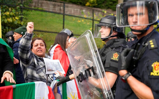 Policemen stand guard as demonstrators gather outside Iran's embassy in Oslo, Norway, Thursday, Sept. 29, 2022, to protest the death of 22-year-old Mahsa Amini in custody in Iran after she was detained by the country’s morality police. (Terje Pedersen/NTB Scanpix via AP)