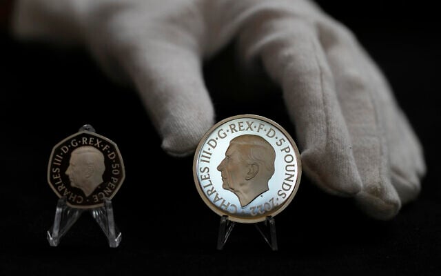Two new coins bearing official coinage portrait of King Charles III, on the left is the new 50 pence coin, and right is the new 5 pound commemorative coin, which will be among the first coins to bear the new king's head, during a press preview in London, September 29, 2022. (AP Photo/Alastair Grant)