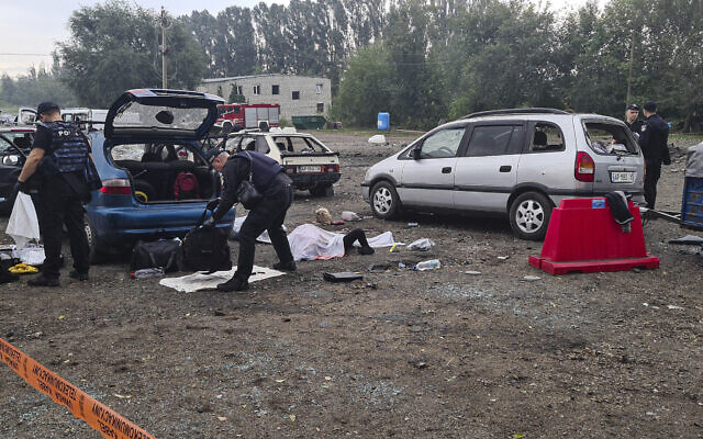 Police officers check the bags of killed civilians after a Russian rocket attack in Zaporizhzhia, Ukraine, Friday, Sept. 30, 2022. (AP Photo/Viacheslav Tverdokhlib) Police officers check the bags of killed civilians after a Russian rocket attack in Zaporizhzhia, Ukraine, Friday, Sept. 30, 2022. (AP Photo/Viacheslav Tverdokhlib)