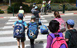 Illustrative: Children cross a street after leaving school in Beit El on May 1, 2019. (Gili Yaari /Flash90)