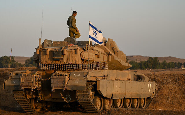 A soldier stands atop a tank ahead of a night drill in the central Golan Heights, on August 29, 2022. (Michael Giladi/Flash90) A soldier stands atop a tank ahead of a night drill in the central Golan Heights, on August 29, 2022. (Michael Giladi/Flash90)