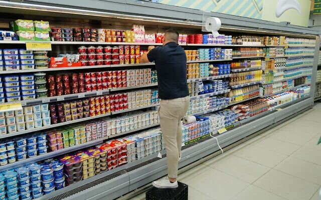 Illustrative: A worker stacks products at a supermarket in the Golan Heights town of Katzrin on September 12, 2022. (Michael Giladi/Flash90) Illustrative: A worker stacks products at a supermarket in the Golan Heights town of Katzrin on September 12, 2022. (Michael Giladi/Flash90)