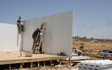 Settler activists rebuild one of the structures at the settlement outpost of Ramat Migron on August 16, 2022. (Jeremy Sharon/Times of Israel)
