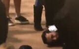 A man is pinned down by British security officers after getting out of line and approaching the coffin of Queen Elizabeth II, at the Palace of Westminster in London, September 17, 2022. (Twitter screenshot, used in accordance with Clause 27a of the Copyright Law)