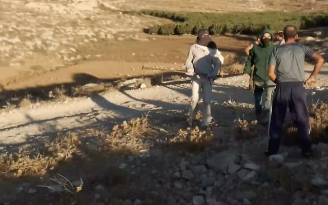 Masked settlers approach a Palestinian man on private Palestinian land close to the Havat Ma'on illegal settlement outpost in the south Hebron Hills, in an incident on September 12, 2022. (Screenshot) Masked settlers approach a Palestinian man on private Palestinian land close to the Havat Ma'on illegal settlement outpost in the south Hebron Hills, in an incident on September 12, 2022. (Screenshot)