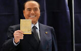 Silvio Berlusconi, leader of the center-right party Forza Italia shows a ballot before casting his vote at a polling station in Milan, Italy, September 25, 2022. (AP Photo/Antonio Calanni)