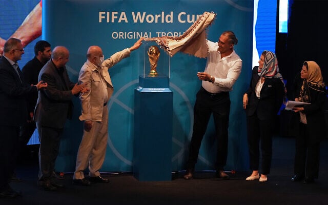 Tehran's city council chairman Mehdi Chamran, left, and former Iranian national soccer team captain Ahmad Reza Abedzadeh, right, reveal the FIFA World Cup trophy during the Trophy Tour, at Milad Tower hall in Tehran, Iran, September 1, 2022. (AP Photo/Vahid Salemi) Tehran's city council chairman Mehdi Chamran, left, and former Iranian national soccer team captain Ahmad Reza Abedzadeh, right, reveal the FIFA World Cup trophy during the Trophy Tour, at Milad Tower hall in Tehran, Iran, September 1, 2022. (AP Photo/Vahid Salemi)
