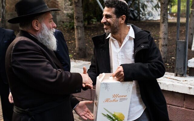Kyiv Chief Rabbi Jonathan Markovich, left, hands a Rosh Hashanah package to a member of the local Jewish community. (Courtesy) Kyiv Chief Rabbi Jonathan Markovich, left, hands a Rosh Hashanah package to a member of the local Jewish community. (Courtesy)
