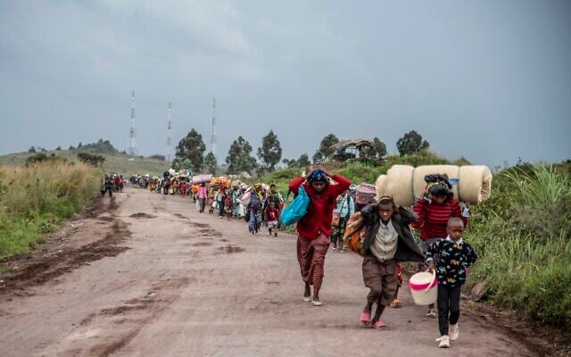 People walk on the road near Kibumba, north of Goma, Democratic Republic of Congo, as they flee fighting between Congolese forces and M23 rebels in North Kivu, May 24, 2022. Congolese authorities have accused Rwandan forces of supporting armed groups in mineral-rich eastern Congo, where dozens of such groups are active. Rwanda has described allegations of supporting rebels in Congo as baseless. (AP Photo/Moses Sawasawa) People walk on the road near Kibumba, north of Goma, Democratic Republic of Congo, as they flee fighting between Congolese forces and M23 rebels in North Kivu, May 24, 2022. Congolese authorities have accused Rwandan forces of supporting armed groups in mineral-rich eastern Congo, where dozens of such groups are active. Rwanda has described allegations of supporting rebels in Congo as baseless. (AP Photo/Moses Sawasawa)