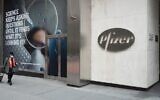 A woman walks in front of Pfizer's headquarters in Manhattan, November 2020. (Massimo Giachetti via iStock by Getty Images)