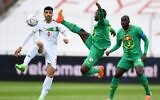 Iran's forward Mehdi Taremi (L) and Senegal's midfielder Nampalys Mendy vie for the ball during the friendly football match between Senegal and Iran in Moedling, Austria on September 27, 2022. (JAKUB SUKUP / AFP)