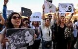 Women protest with placards during the unveiling of a banner on the facade of the town hall in support of the Iranians fighting for their freedom and against obscurantism in their country, in Montpellier, southern France, on October 3, 2022. (Pascal GUYOT / AFP)