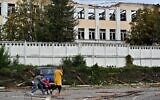 A family walks past a building destroyed by Russian, Iranian-made, drones after an airstrike on Bila Tserkva, southwest of Kyiv, on October 5, 2022, amid the Russian invasion of Ukraine. (Sergei Supinsky/AFP)