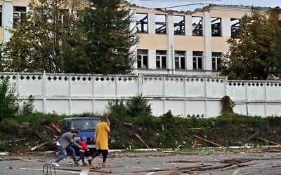 A family walks past a building destroyed by Russian, Iranian-made, drones after an airstrike on Bila Tserkva, southwest of Kyiv, on October 5, 2022, amid the Russian invasion of Ukraine. (Sergei Supinsky/AFP) A family walks past a building destroyed by Russian, Iranian-made, drones after an airstrike on Bila Tserkva, southwest of Kyiv, on October 5, 2022, amid the Russian invasion of Ukraine. (Sergei Supinsky/AFP)