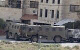 Israeli security forces vehicles are parked near a building during an operation in Jenin in the West Bank, on October 8, 2022. (Jaafar Ashtiyeh/AFP)