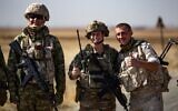 Soldiers of a Russian military convoy and their US counterparts pose for pictures as their patrol routes intersect in an oil field near Syria's al-Qahtaniyah town in the northeastern Hasakah province, close to the border with Turkey, on Octobre 8, 2022. (Delil Souleiman/AFP)