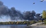 Birds fly as smoke rises over Dnipro River after several Russian strikes hit the Ukrainian capital of Kyiv on October 10, 2022. (Genya Savilov/AFP)
