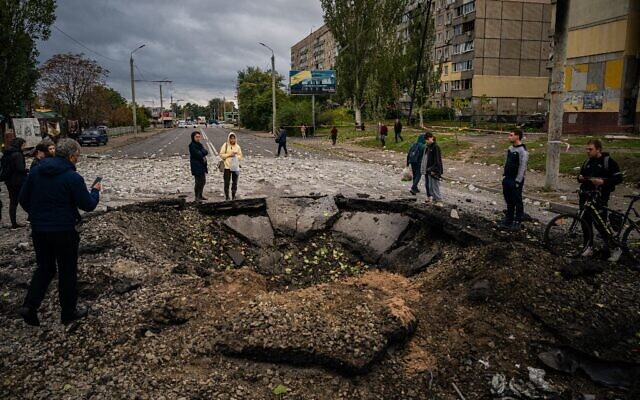 Local residents examine a crater following a missile strike in Dnipro on October 10, 2022, amid Russia's invasion of Ukraine. (Dimitar Dilkoff/AFP) Local residents examine a crater following a missile strike in Dnipro on October 10, 2022, amid Russia's invasion of Ukraine. (Dimitar Dilkoff/AFP)