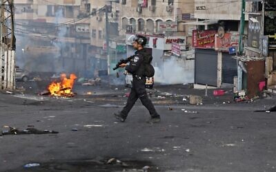 A police officer is seen in the Shuafat refugee camp in East Jerusalem, during clashes with Palestinians, on October 12, 2022. (Ahmad Gharabli/AFP)