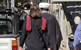 A picture obtained by AFP outside Iran shows a woman walking without a head scarf in the heart of the Iranian capital Tehran, on October 11, 2022. (AFP)