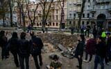 People gather by a rocket crater in a park of central Kyiv on October 12, 2022, two days after Ukraine's capital was hit by multiple Russian strikes (Dimitar DILKOFF / AFP)