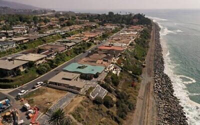 In this aerial view, train tracks follow along a coastline now devoid of all sand, near the exclusive Cyprus Shore residential community in San Clemente, California, on October 12, 2022. (Robyn Beck/AFP)